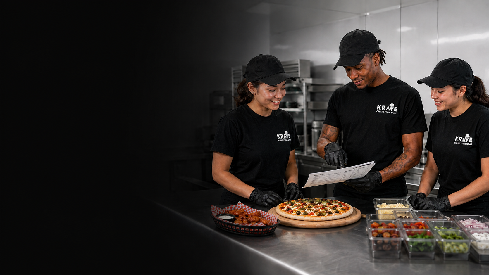 Three Krave employees reviewing a recipe and working together in a clean back-of-house kitchen
