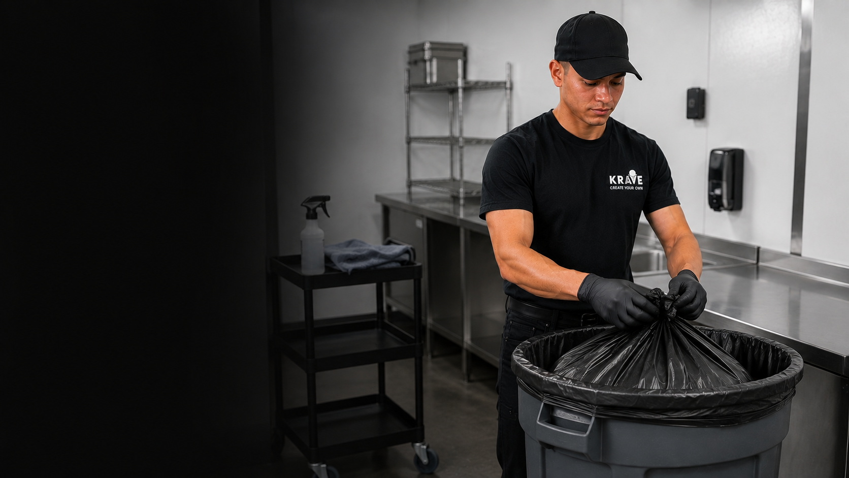 A Krave employee removing a trash liner in a back-of-house utility area