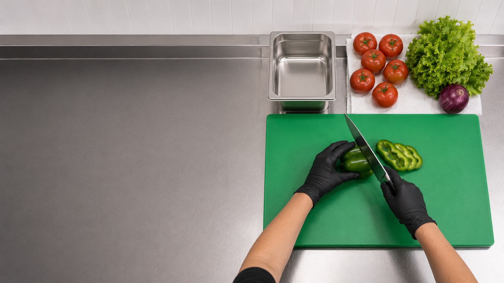 Dry produce prepared with fresh gloves, a clean knife, a green cutting board, and a clean food pan